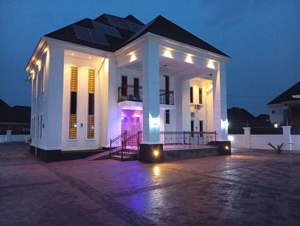 a white house with lights on it at night at King Arthur Apartment in Akwa