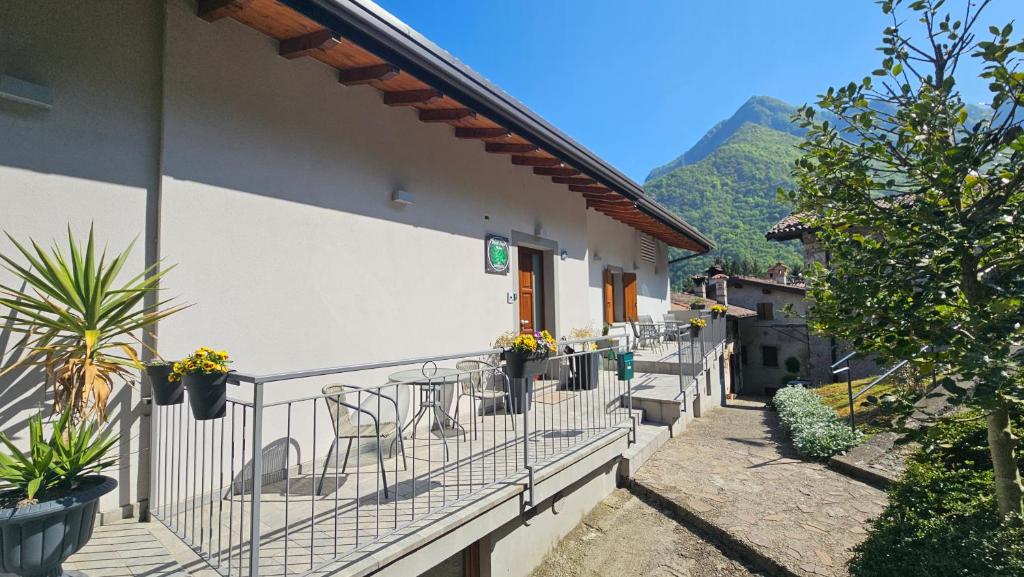 a balcony of a building with tables and chairs at Monte Zucco Relax self check in in San Pellegrino Terme