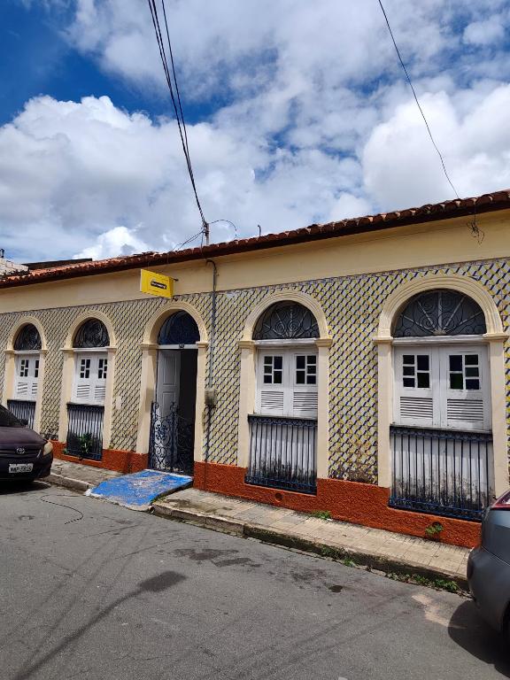 a building with white doors and windows on a street at durmaaquislz in São Luís