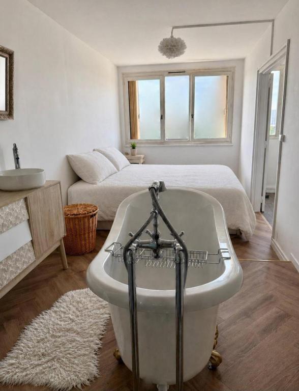 a bathroom with a bath tub in front of a bed at Paris Appartement 2-pièce Master Bedroom Romantique in Alfortville