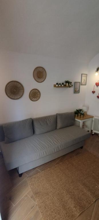 a living room with a couch against a white wall at Casa da Capinha Rota - Moura in Moura