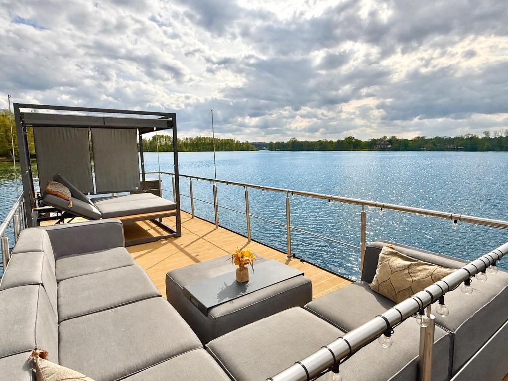 a deck of a boat with a couch and a table at Hausboot TraumZeitBoot Jutta - exklusiver Festlieger in perfekter Lage am Scharmützelsee Bad Saarow in Bad Saarow