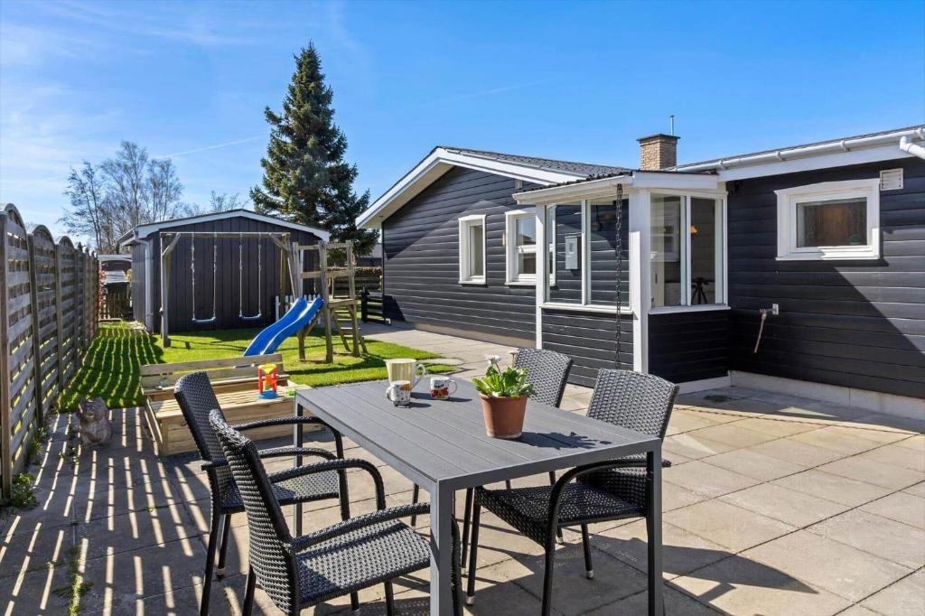 a patio with a table and chairs and a house at 8501-Grenaa-Ellevej-14 in Grenå Strand