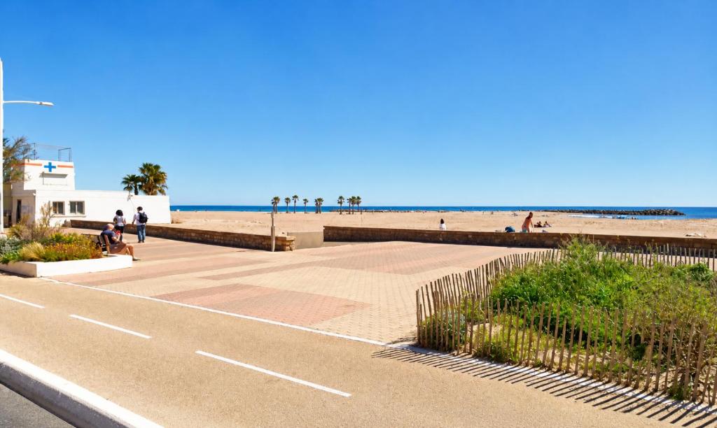 a road next to a beach with people on it at Studio cosy Valras, plage à 20 m in Valras-Plage