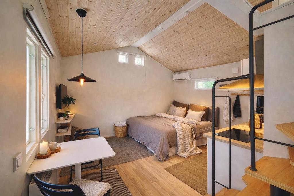 a bedroom with a bed and a table in a room at Central, Modern, Cozy Cottage in Gävle