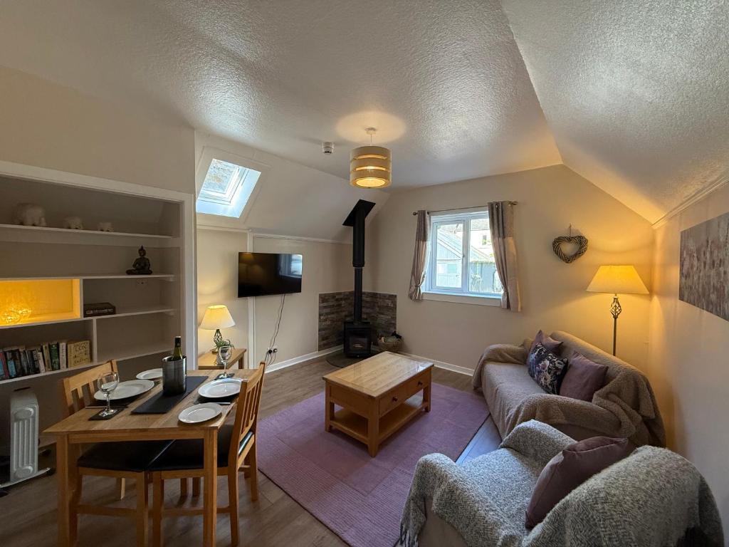 a living room with a couch and a table at Willows Cottage in Pitlochry