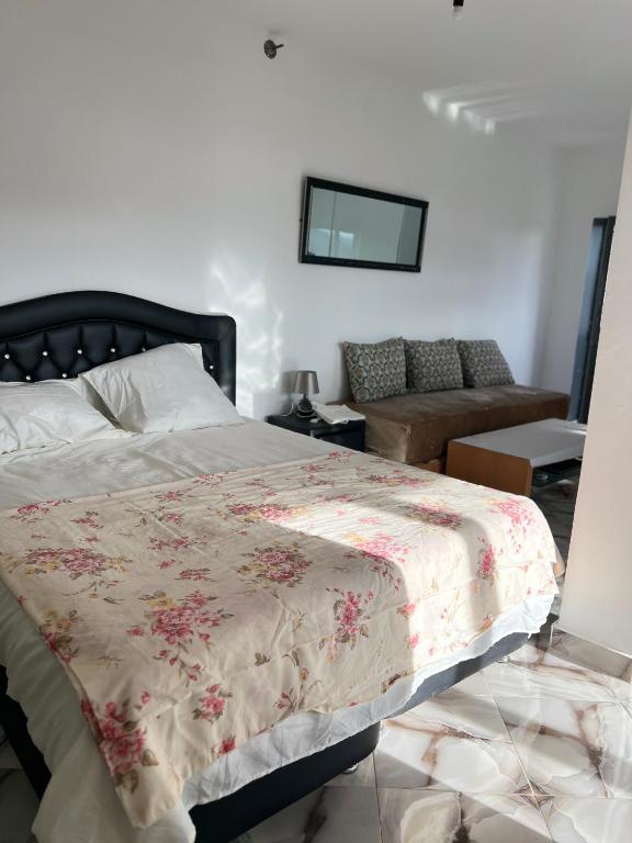 a bedroom with a bed with a flowered blanket at Zinat outdoor villa in Tétouan
