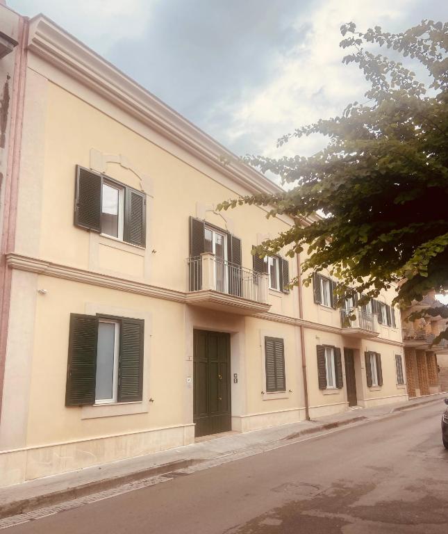 a building with black shuttered windows on a street at Il Cavaliere Bed and Breakfast in Caserta