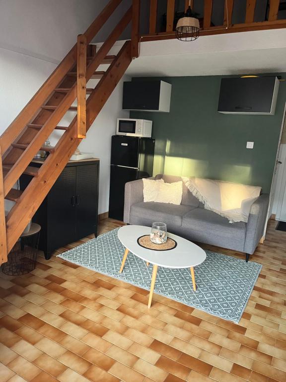 a living room with a couch and a table at Vacances Cap d'Agde 1 chambre, 1 mezzanine, parking et piscine in Cap d'Agde