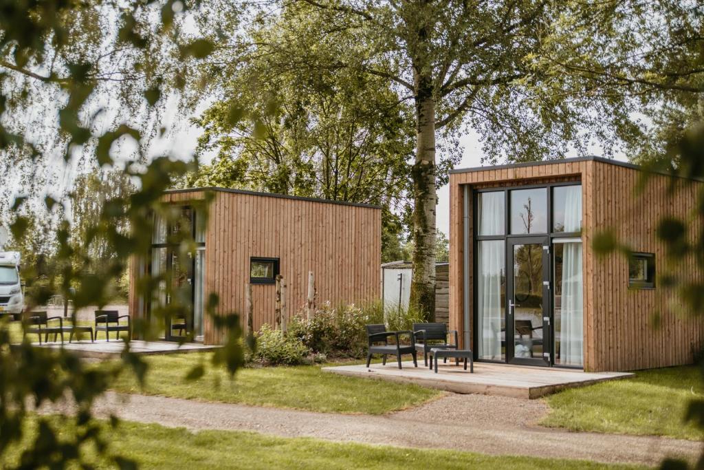 a tiny house in a garden with benches at Tiny House in Kesteren
