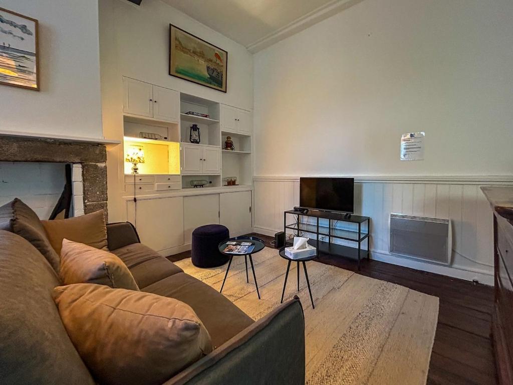 a living room with a couch and a television at Petit Cocon Intra-muros in Saint Malo
