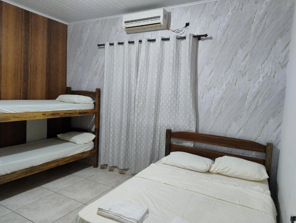 a bedroom with two bunk beds and a fan at Pesqueiro Rancho dos Reis in Aquidavana