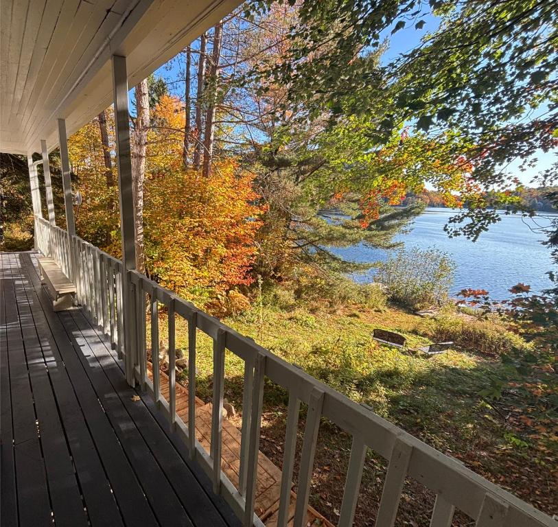 a porch of a house with a view of a lake at Gîte du Lac-à-la-Loutre - B&B in Huberdeau