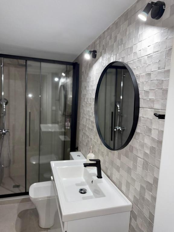 a bathroom with a sink and a mirror and a toilet at Mabys home in Chalkida