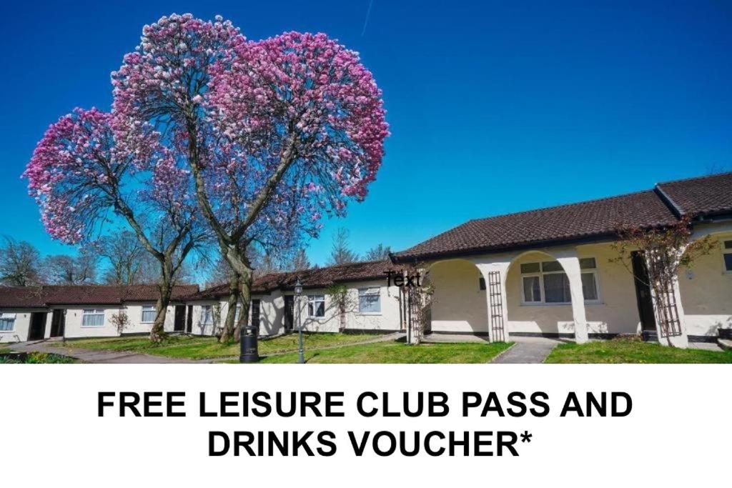 a tree with pink flowers in front of a house at Park Hall Cottages ,Chorley, Preston,Lancashire in Chorley
