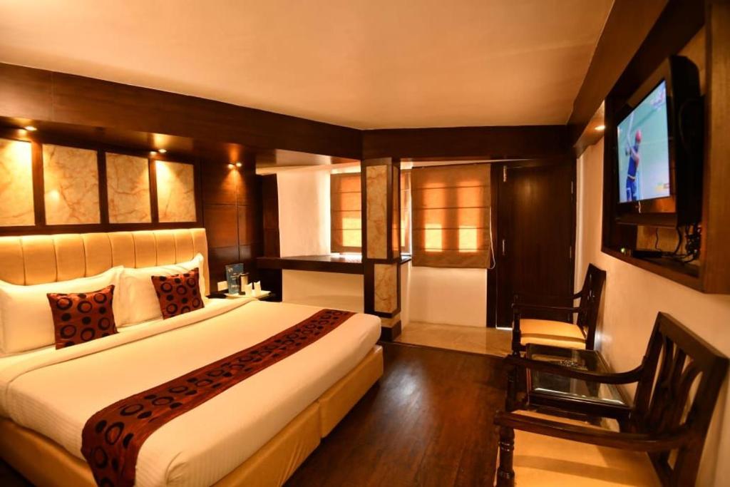 a bedroom with a large bed and a television at Hotel Morning Lake in Nainital