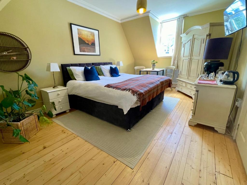a bedroom with a large bed with blue pillows at Room 2, Wedale House in Stow