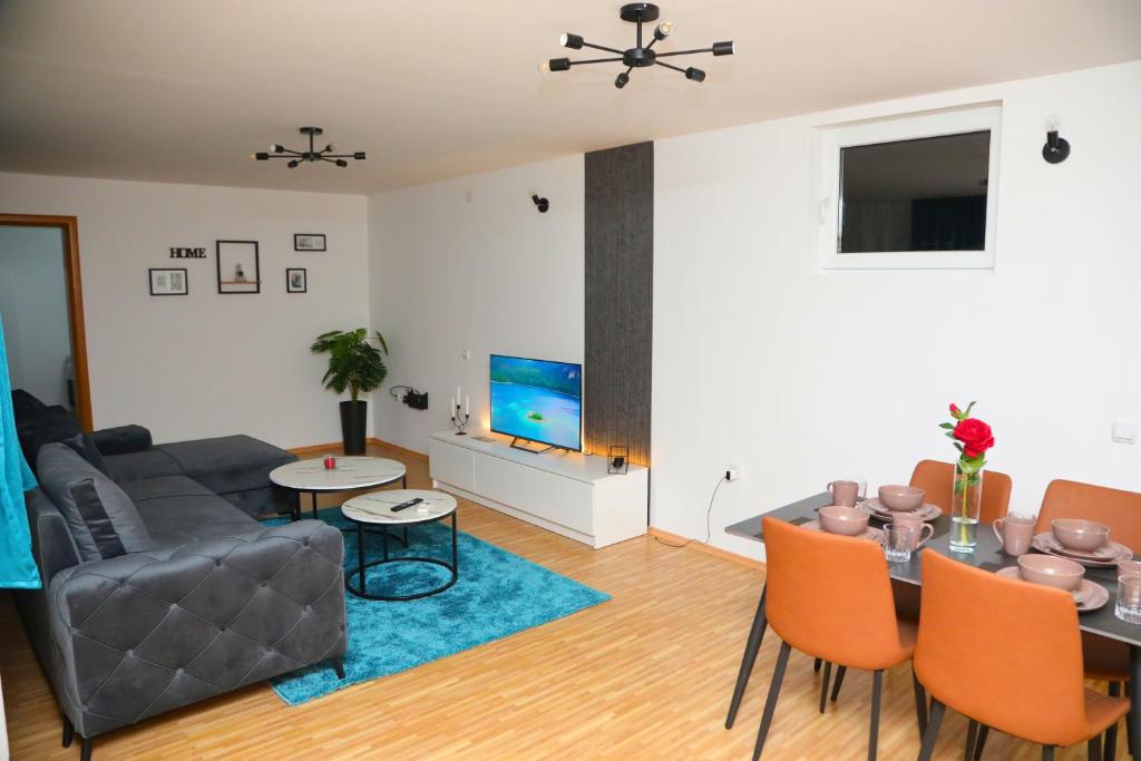 a living room with a couch and a table at City Apartman 101 in Bosanski Brod