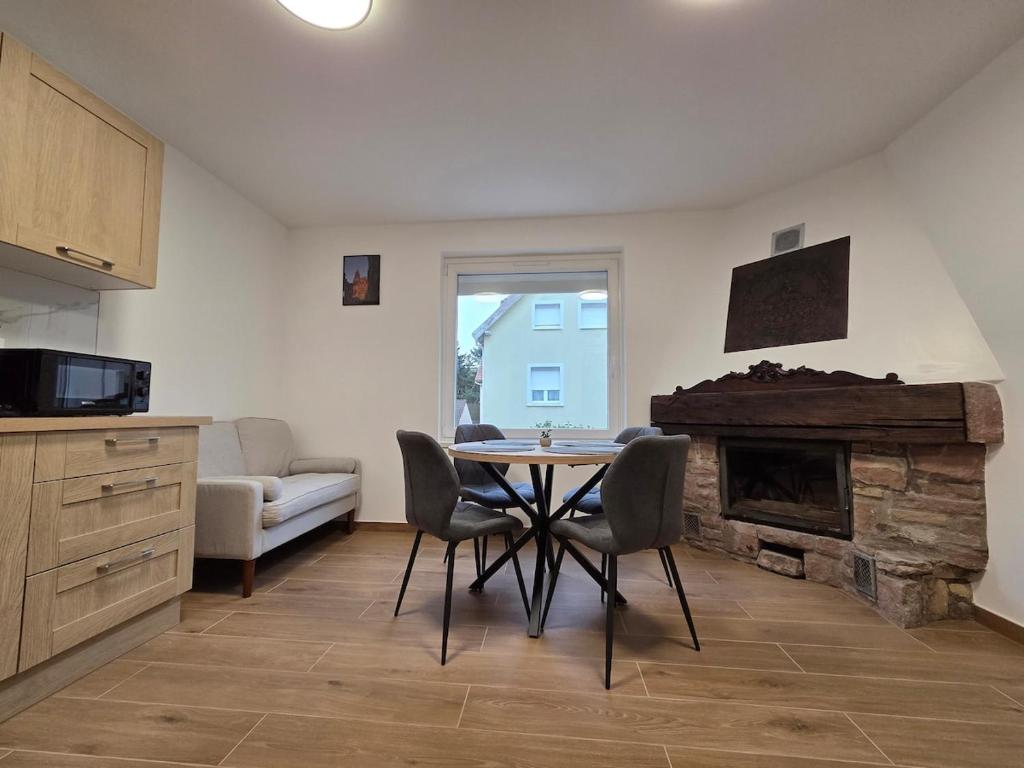 a living room with a table and a fireplace at Le Nid d'Étoiles in Schiltigheim