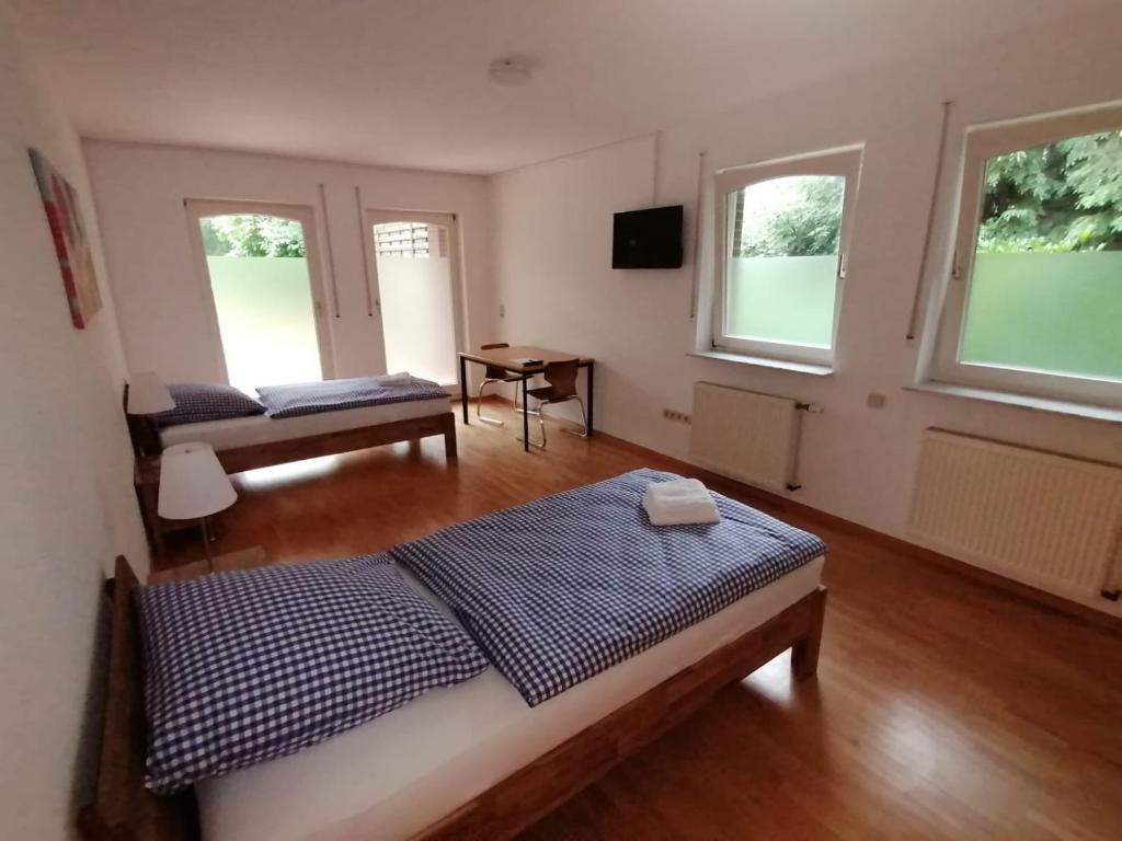 a bedroom with a bed and a table and windows at Ferienwohnung Haus Lohne in Lohne