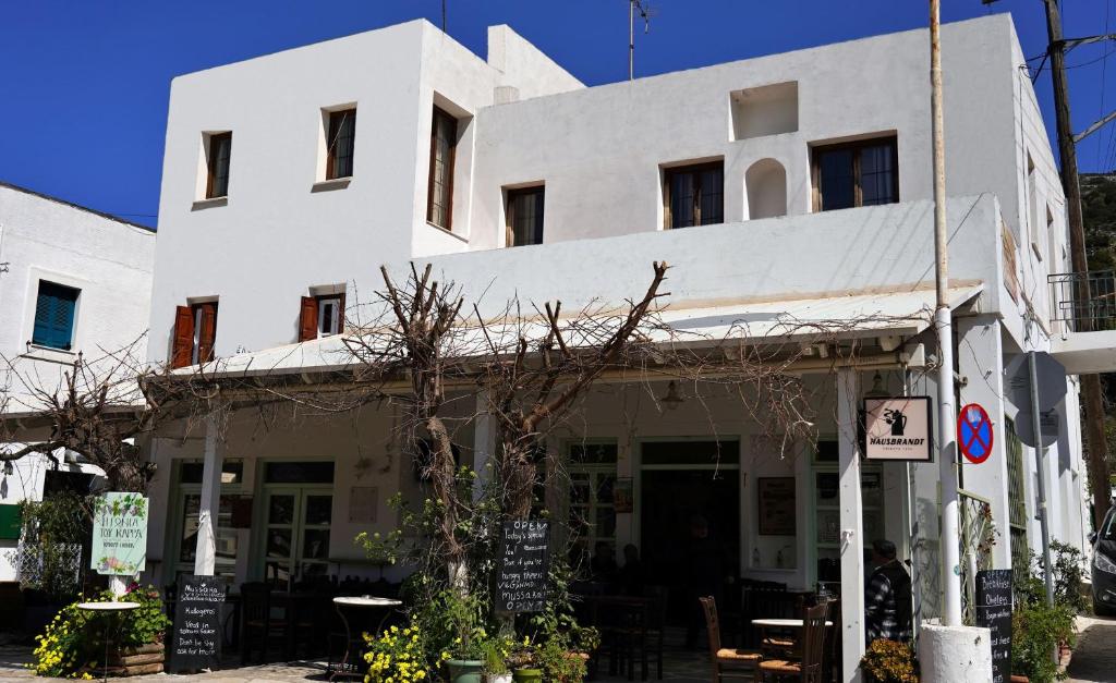 a white building with tables in front of it at Gefyra Studios Filoti Naxos in Filótion