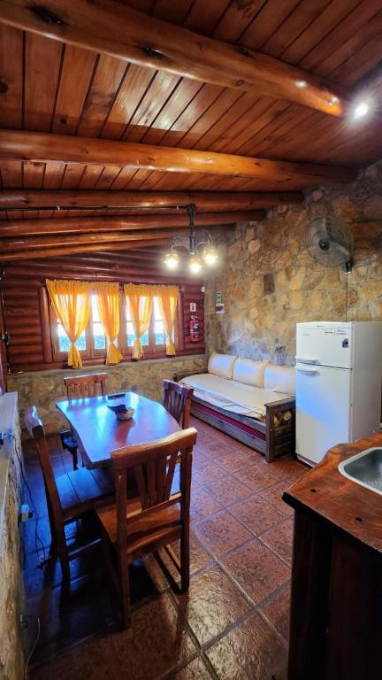 a living room with a table and a couch and a refrigerator at Aypa Pacha Nono in Nono