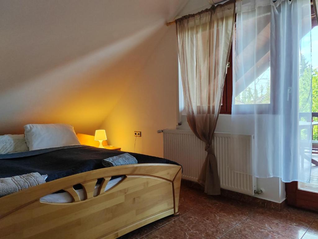 a bedroom with a bed and a large window at Guest Zimmer Nora in Zamárdi
