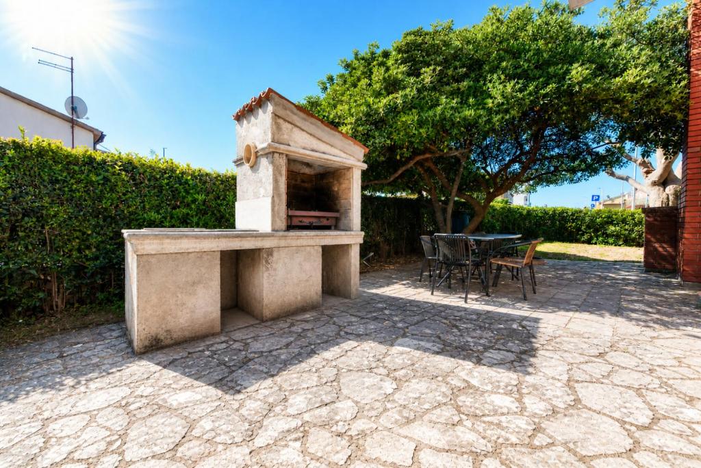 a stone outdoor oven with a table and chairs at Enjoy & Relax Da Elvia in Rovinj