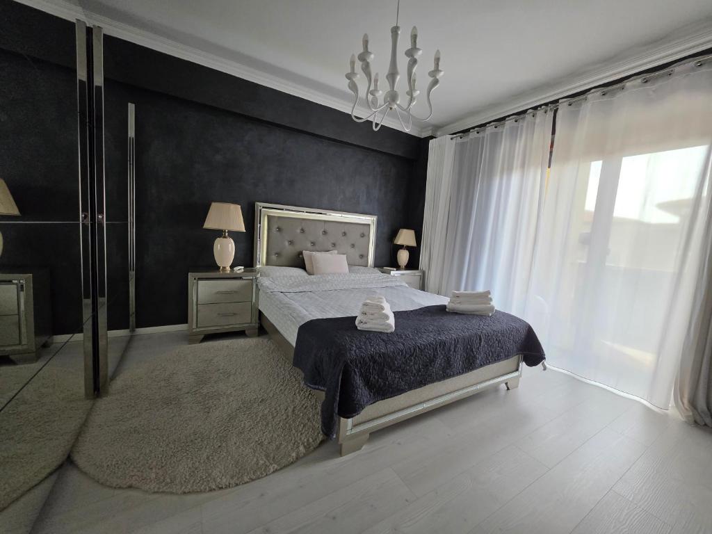 a bedroom with a bed and a large window at JohnResidence in Valea Lupului