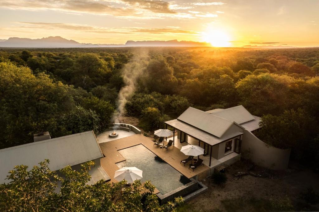 an aerial view of a house with the sun in the distance at Ujima Lodge in Hoedspruit