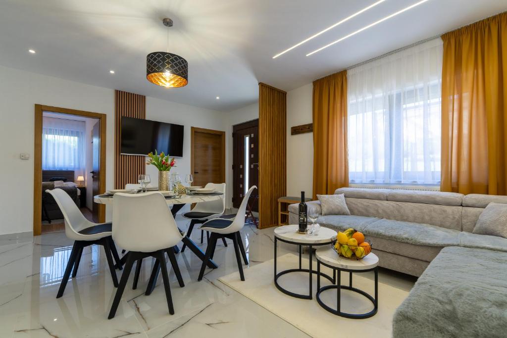 a living room with a couch and tables and chairs at Silentium Apartment in Donji Prozor