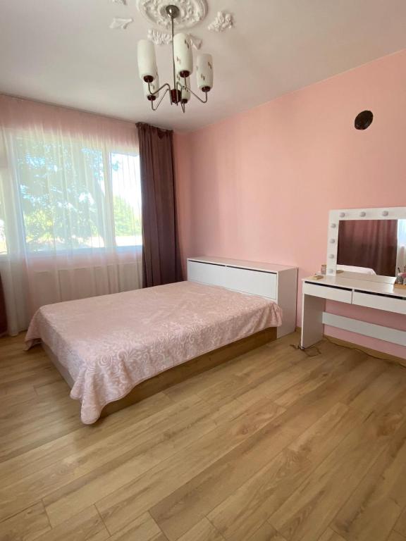 a pink bedroom with a bed and a desk at Emis apartment in Targovishte