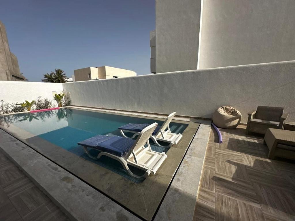 two chairs sitting next to a swimming pool at Villa Donia in Mezraya