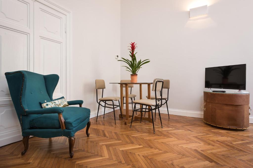 salon ze stołem, krzesłami i telewizorem w obiekcie Casa Minerva Al Pantheon w Rzymie