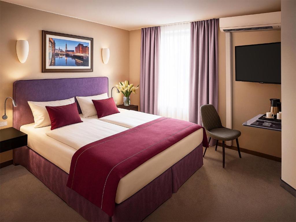 ein Hotelzimmer mit einem großen Bett und einem Fernseher in der Unterkunft Hotel Hafentor in Hamburg