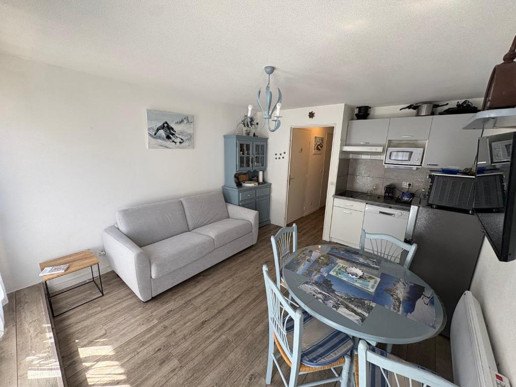 a living room with a table and a couch at Appartement 4 personnes avec terrasse Centre ville in Cauterets