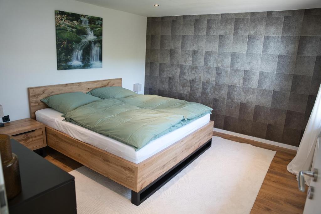 a bedroom with a bed with a wooden headboard at Ferienwohnung Mangfalltal in Bruckmühl