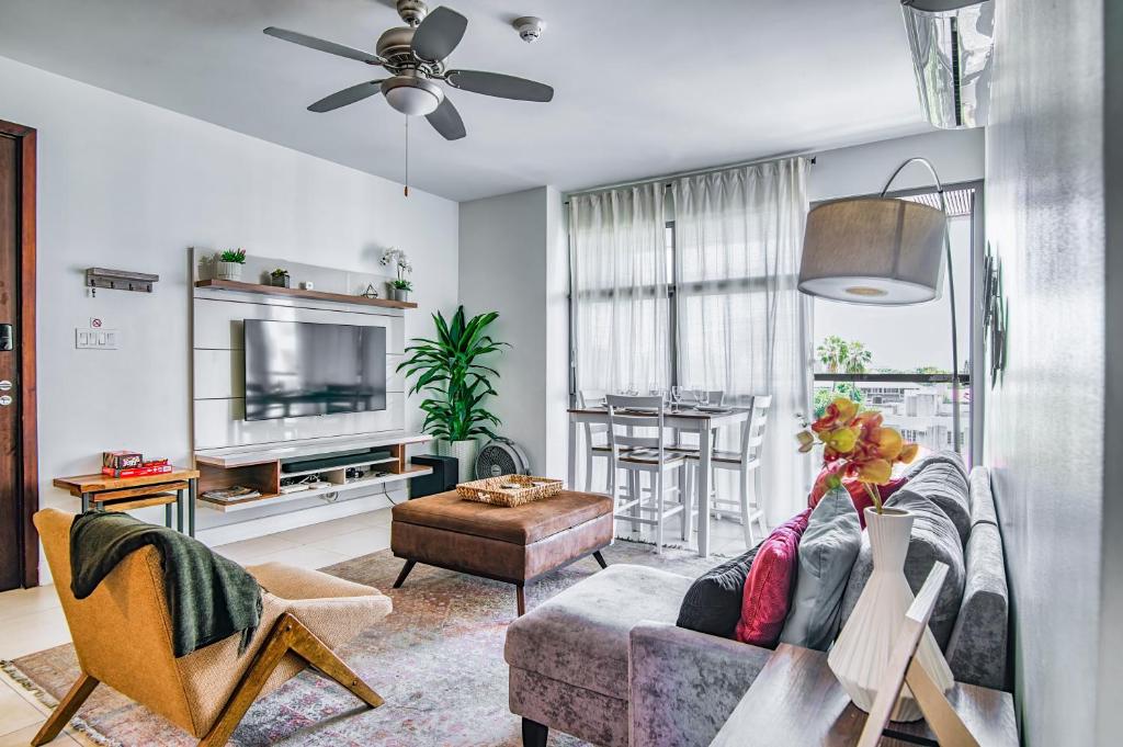 a living room with a couch and a tv at Airy Modern 2br Condo Rooftop Pool in Kingston