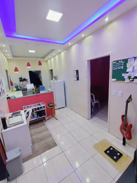 a room with a kitchen with a guitar on the wall at Casa completa aconchegante proximo a praia in São Luís