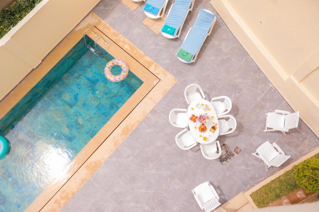 an overhead view of a swimming pool with a table and chairs at Villa d'exception - Piscine à débordement - Vue sur la mer - Barbecue - Salle de sport - Jusqu'à 12 personnes in Feddane Chappo