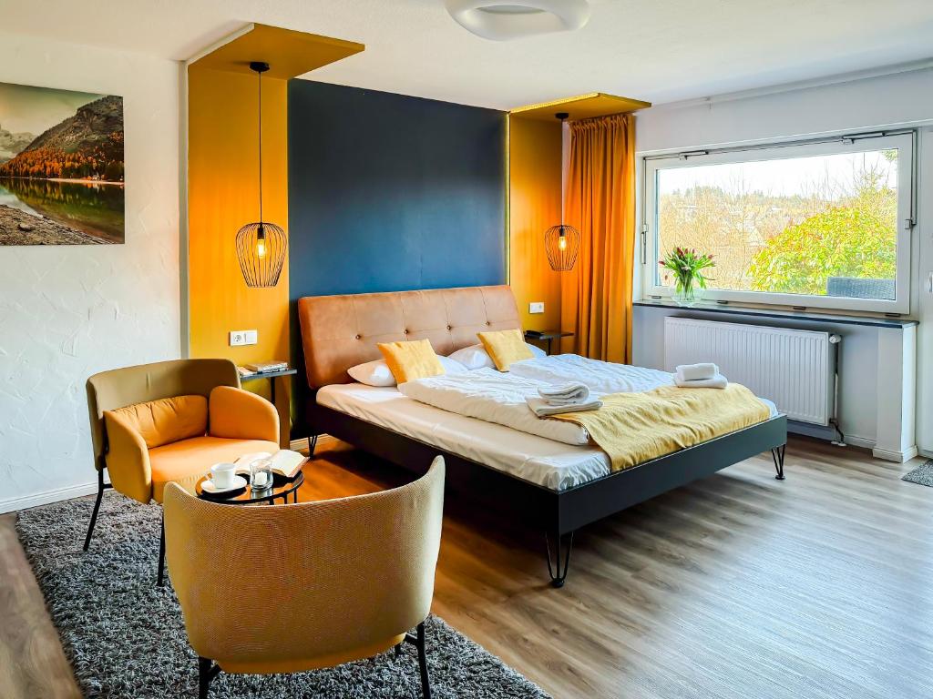 a bedroom with a bed and a couch and a chair at Blissberg Winterberg in Winterberg