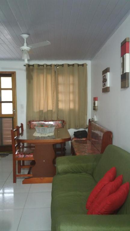 uma sala de estar com um sofá verde e uma mesa em Aconchego Na Maranduba Em Ubatuba em Ubatuba
