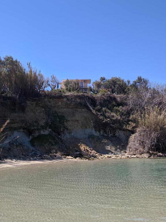 a house on a hill next to a body of water at Casa di Nonno in Alikanas