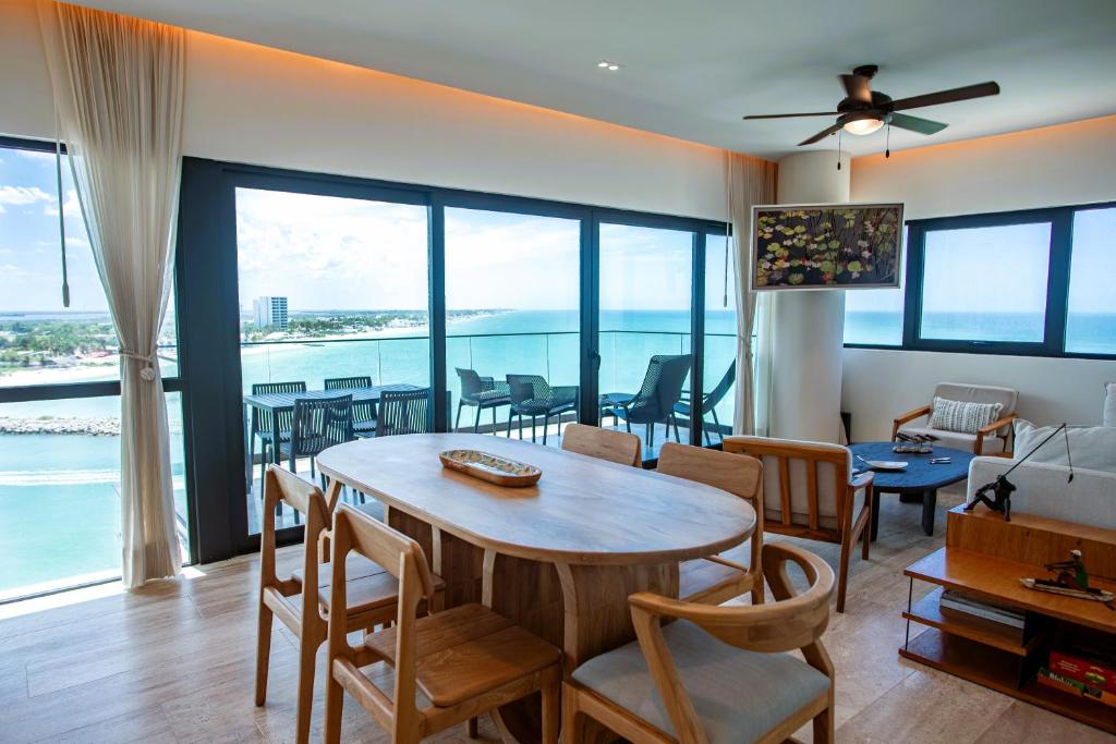 a living room with a table and chairs at Ocean's Embrace and unforgetful sunsets in Progreso