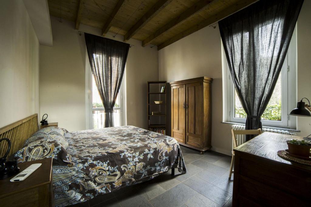 ein Schlafzimmer mit einem Bett, einer Kommode und zwei Fenstern in der Unterkunft Antico Borgo in Mailand