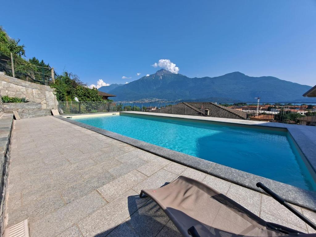 a swimming pool with a mountain in the background at Immobillario - Casa Luna in Domaso