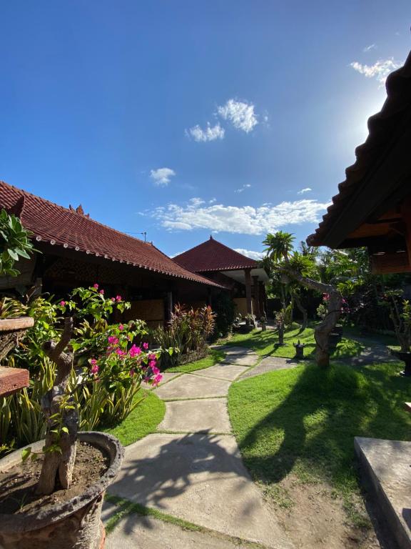 a garden with flowers and plants in front of a building at Tebu menjangan homestay in Banyuwedang