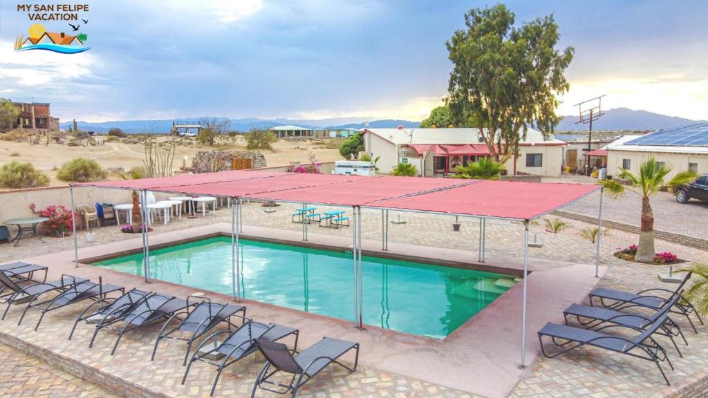 a swimming pool with chairs and a red roof at Paradise home in Rancho Percebu in San Felipe