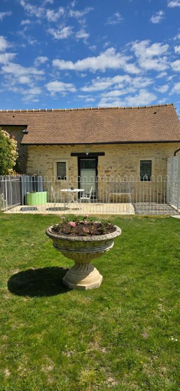 a statue in the grass in front of a building at Gite "Le Cosy Fleuri" in Champenard