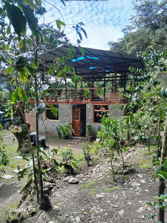 a house with a black roof in a garden at Etrita Inkas Hostel in Sahuayacu